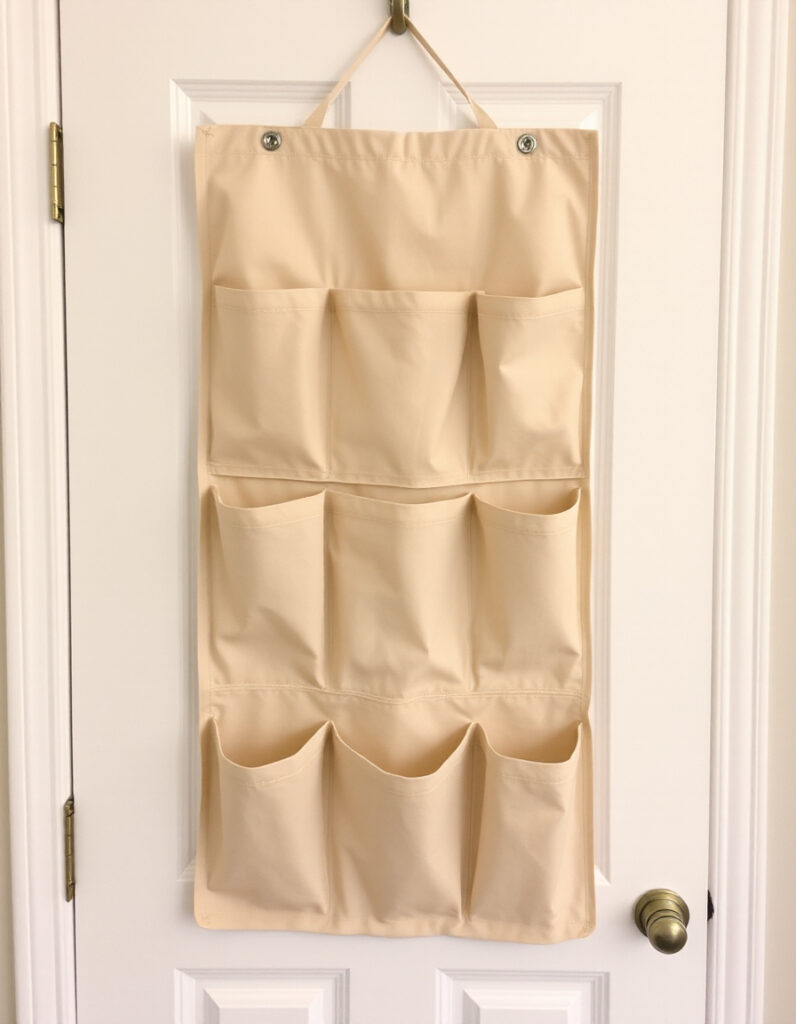 A neutral fabric organizer  hanging over a white door.